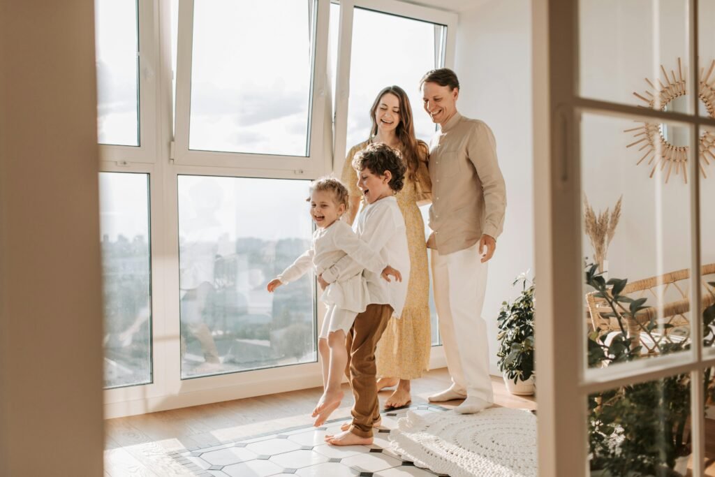 A joyful family of four enjoying time together in a bright, modern living room.